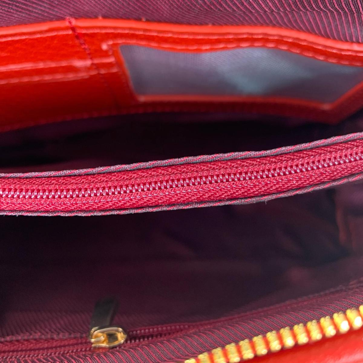 Close-up view of red leather clutch bag interior compartments