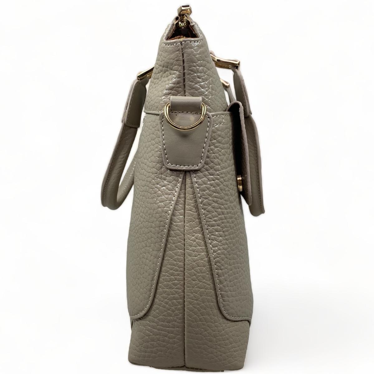 Side angle of cream leather laptop bag displaying the structured shape and professional appearance