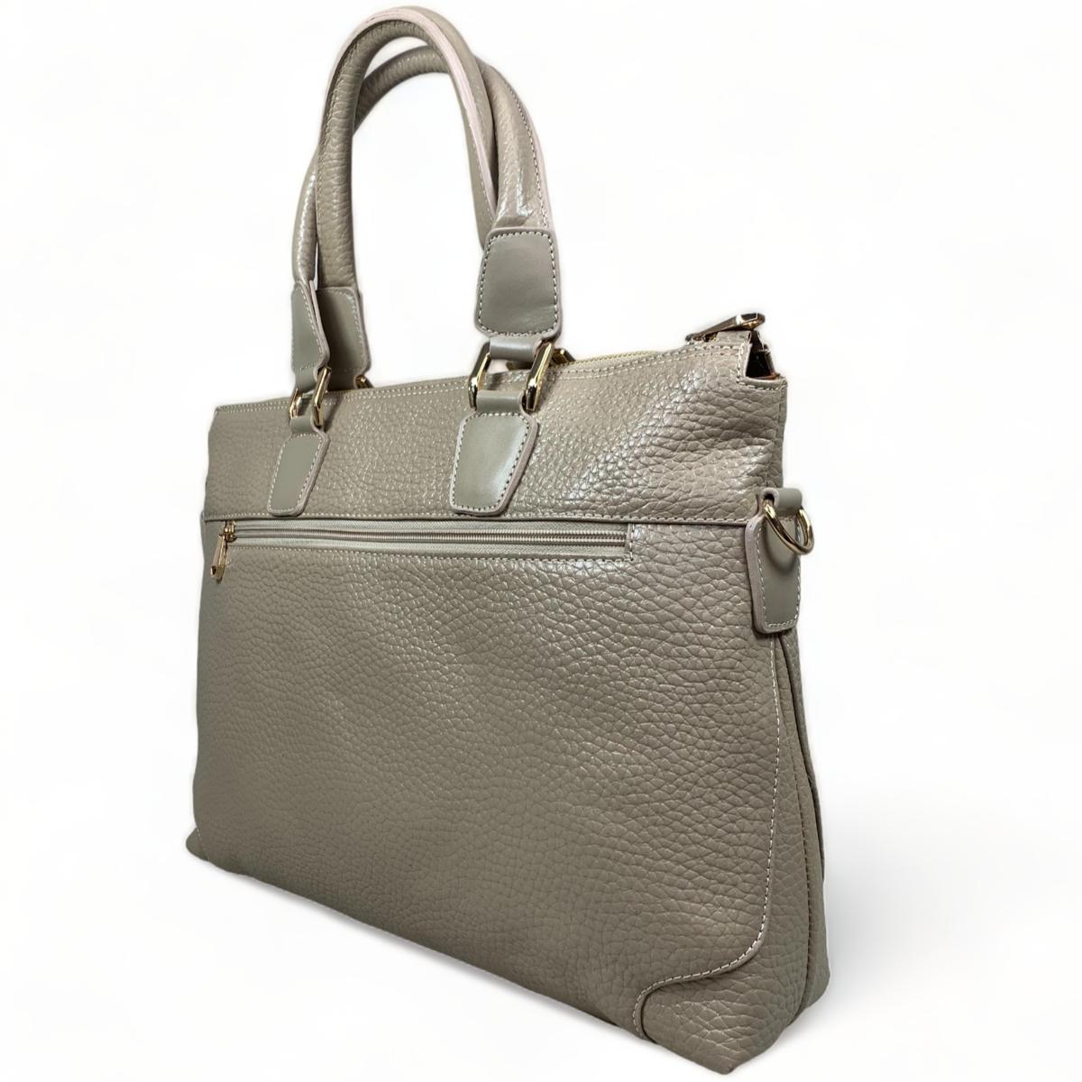 Side angle of cream leather laptop bag displaying the structured shape and professional appearance