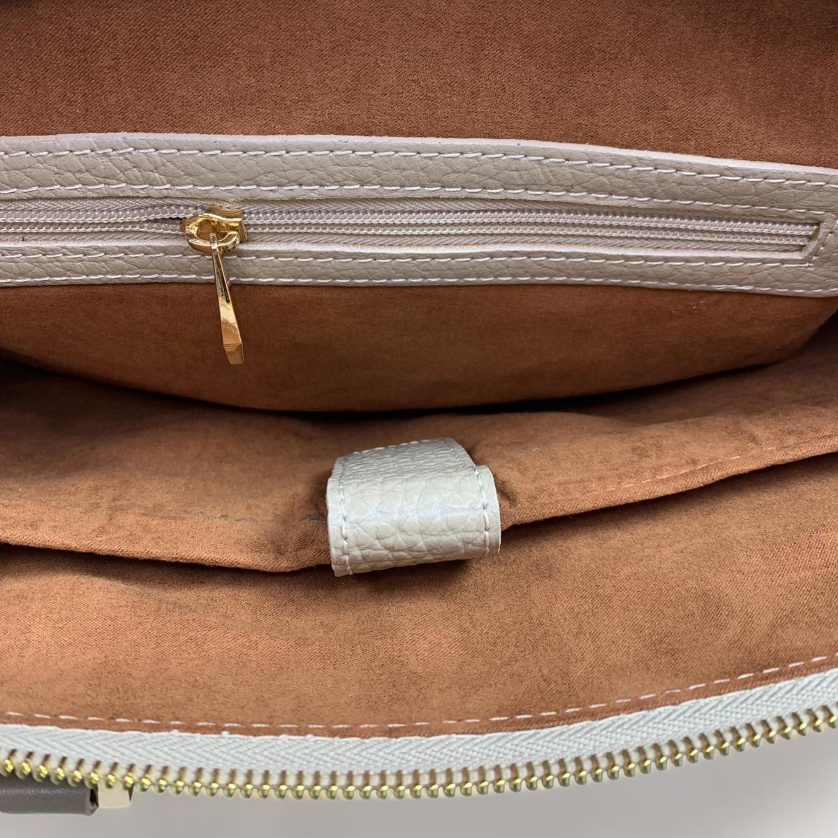 Interior view of cream leather laptop bag showing multiple compartments and organizational pockets
