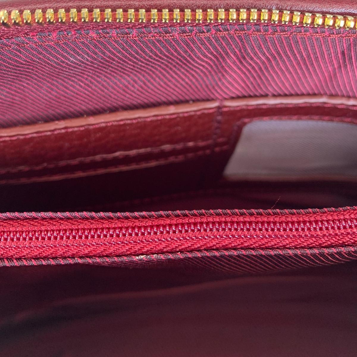 Leather clutch interior showing three compartments and zip pockets