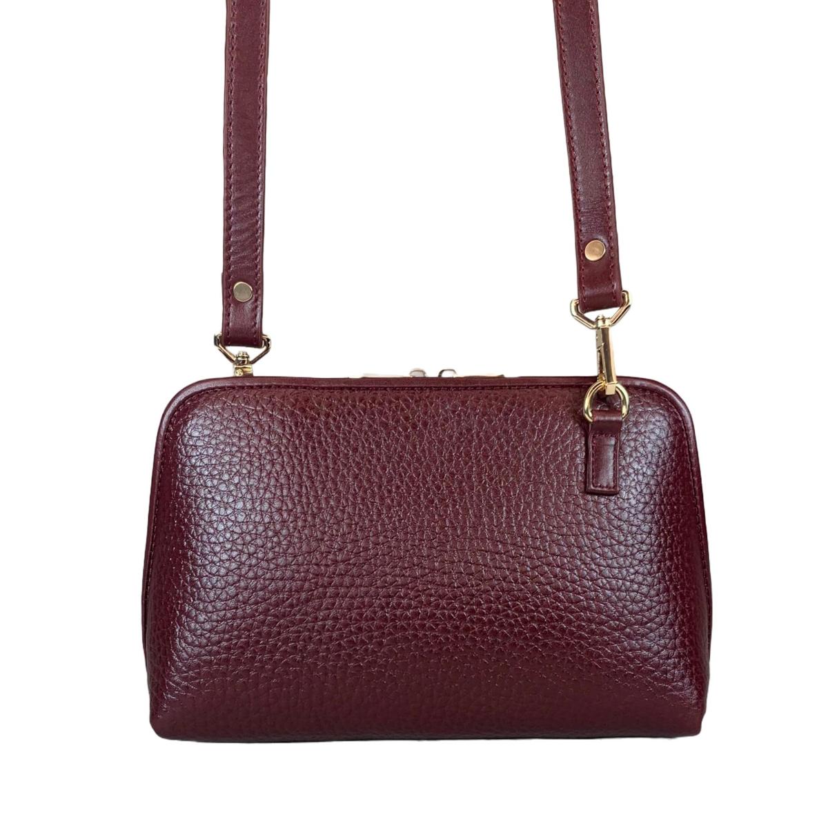 Dark red clutch bag worn as crossbody showing versatile styling
