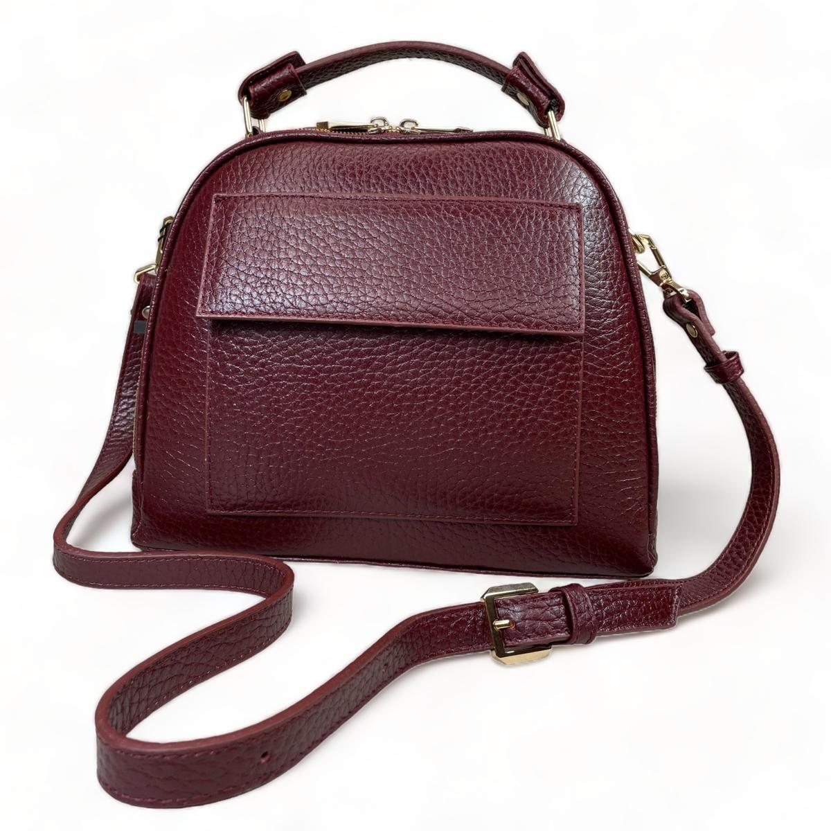 Three-quarter front view of dark red leather satchel with detachable, adjustable strap
