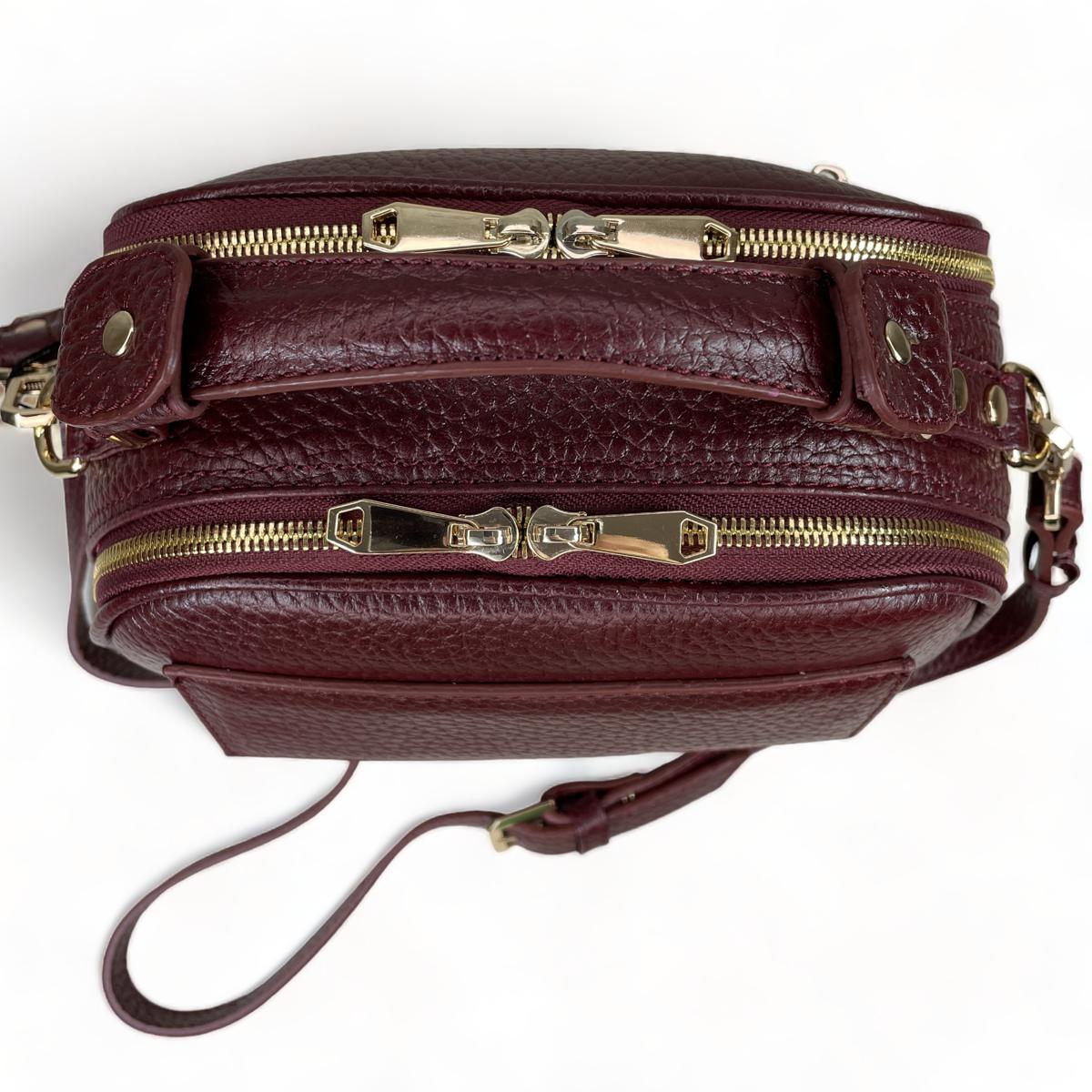Top view of dark red leather satchel showing double-zip closures and gold-tone hardware