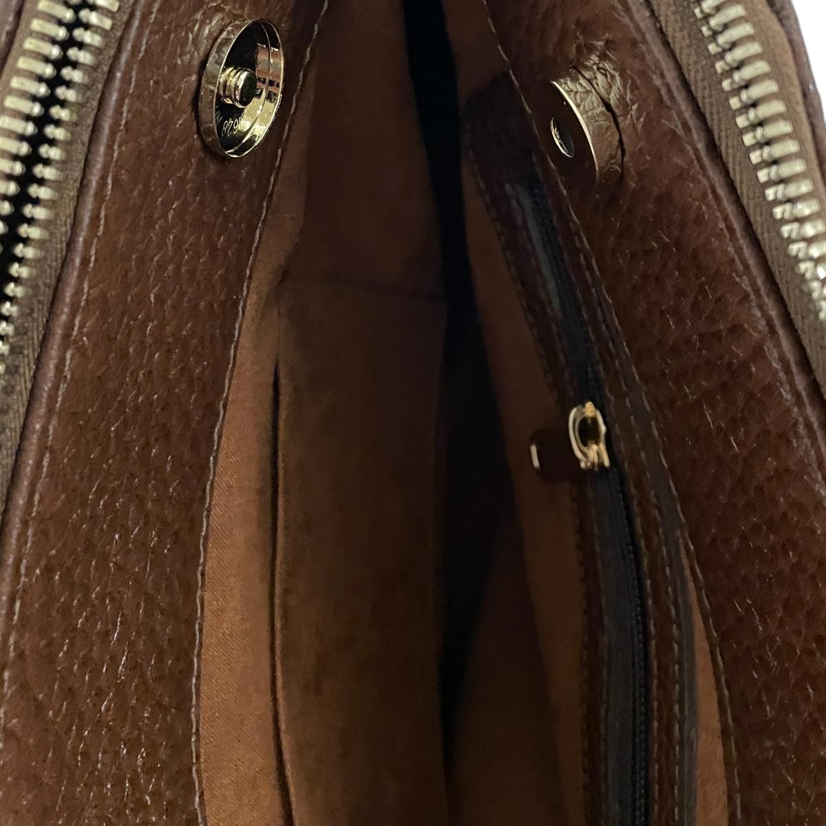 Interior view of brown leather office bag showing internal zip pocket and organization