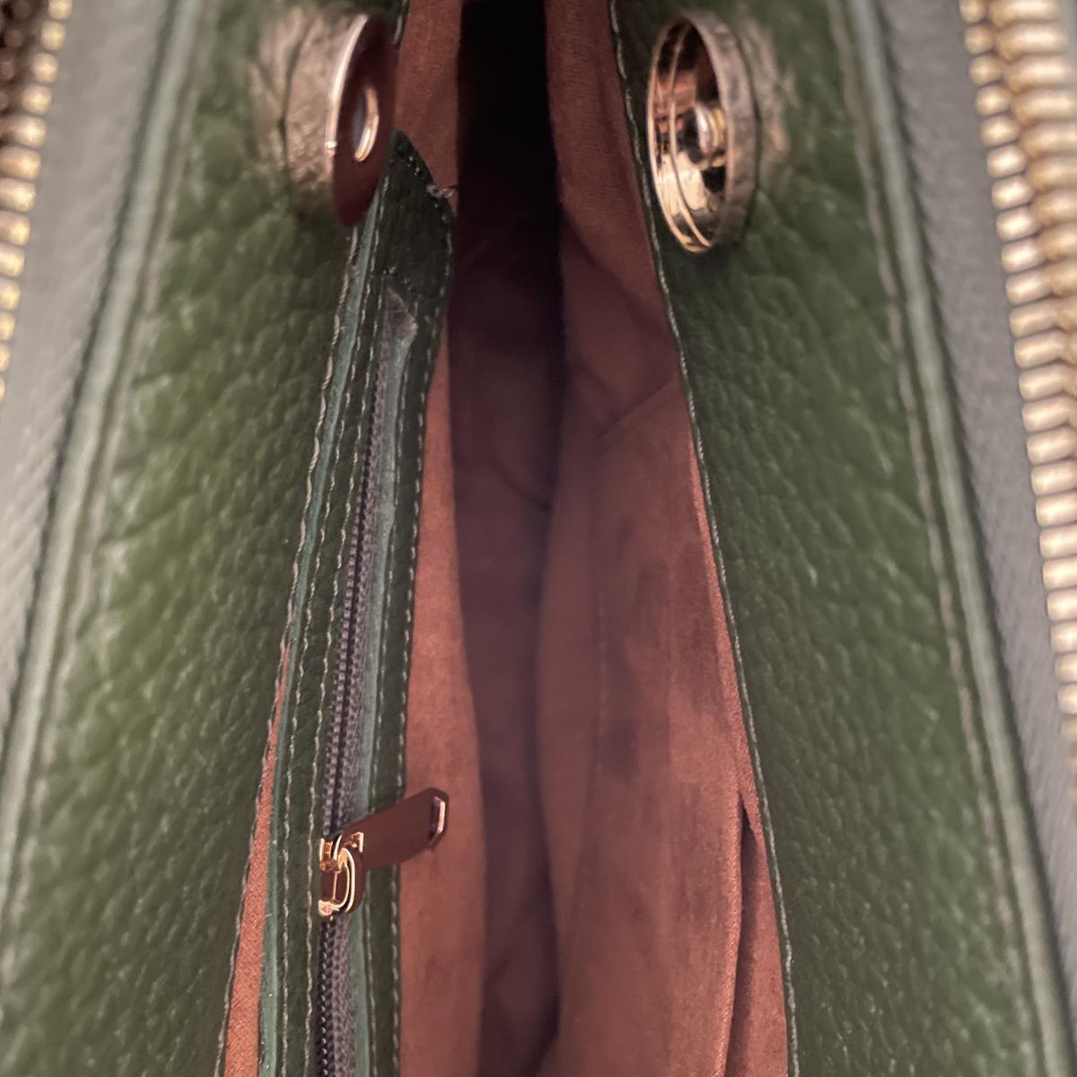 Close-up of green leather office bag’s detachable adjustable shoulder strap and hardware