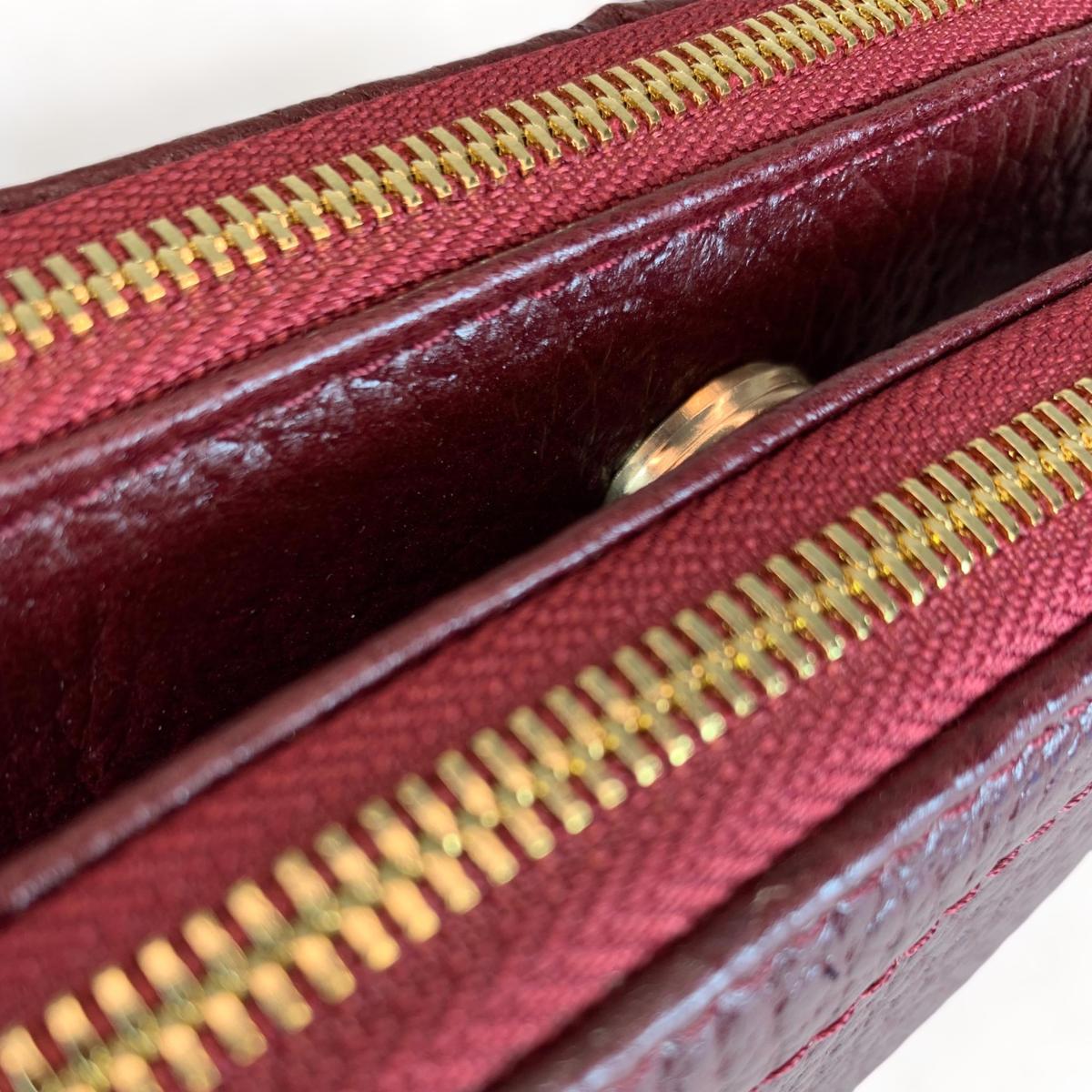 Interior view of red leather shoulder bag displaying three compartments and zip pocket