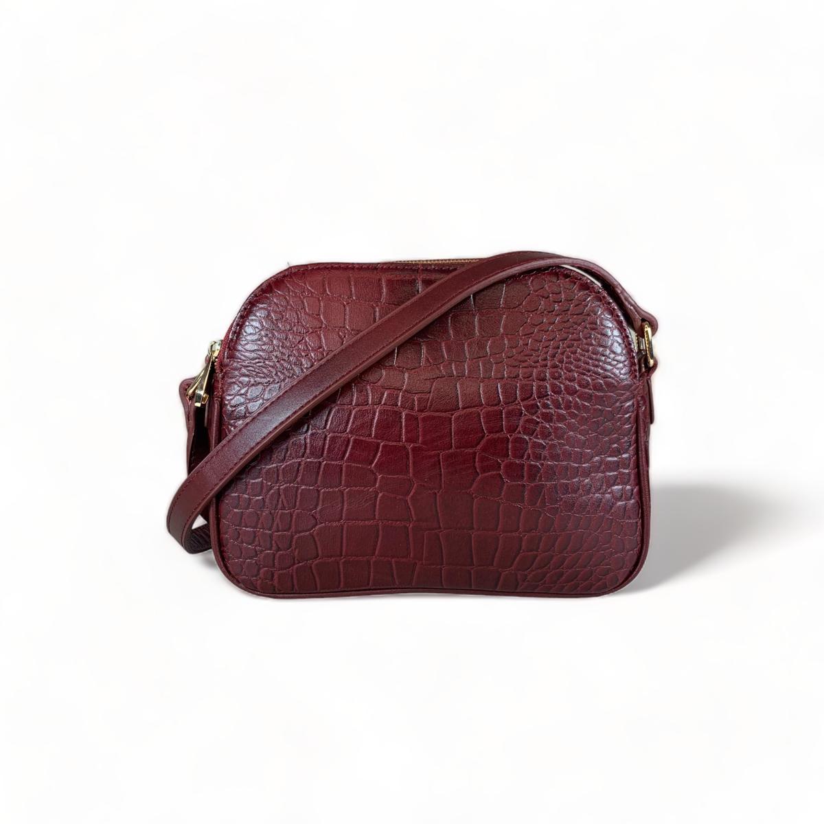 Dark red leather shoulder bag showing top zip and crocodile texture
