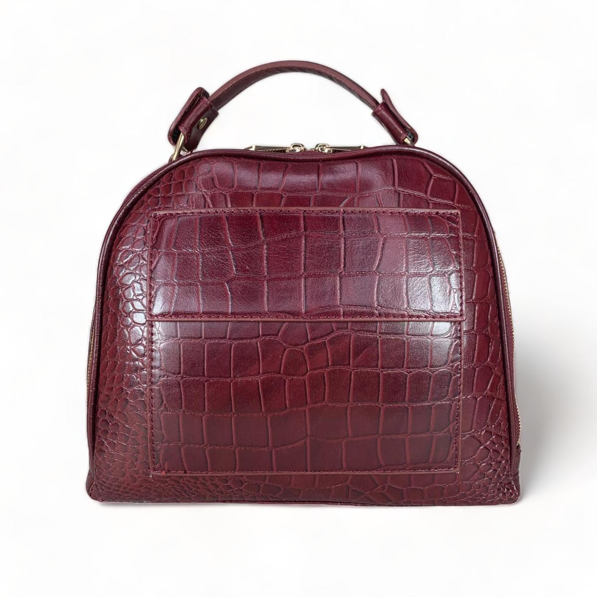 Close-up of red leather handbag showing premium grain texture and craftsmanship