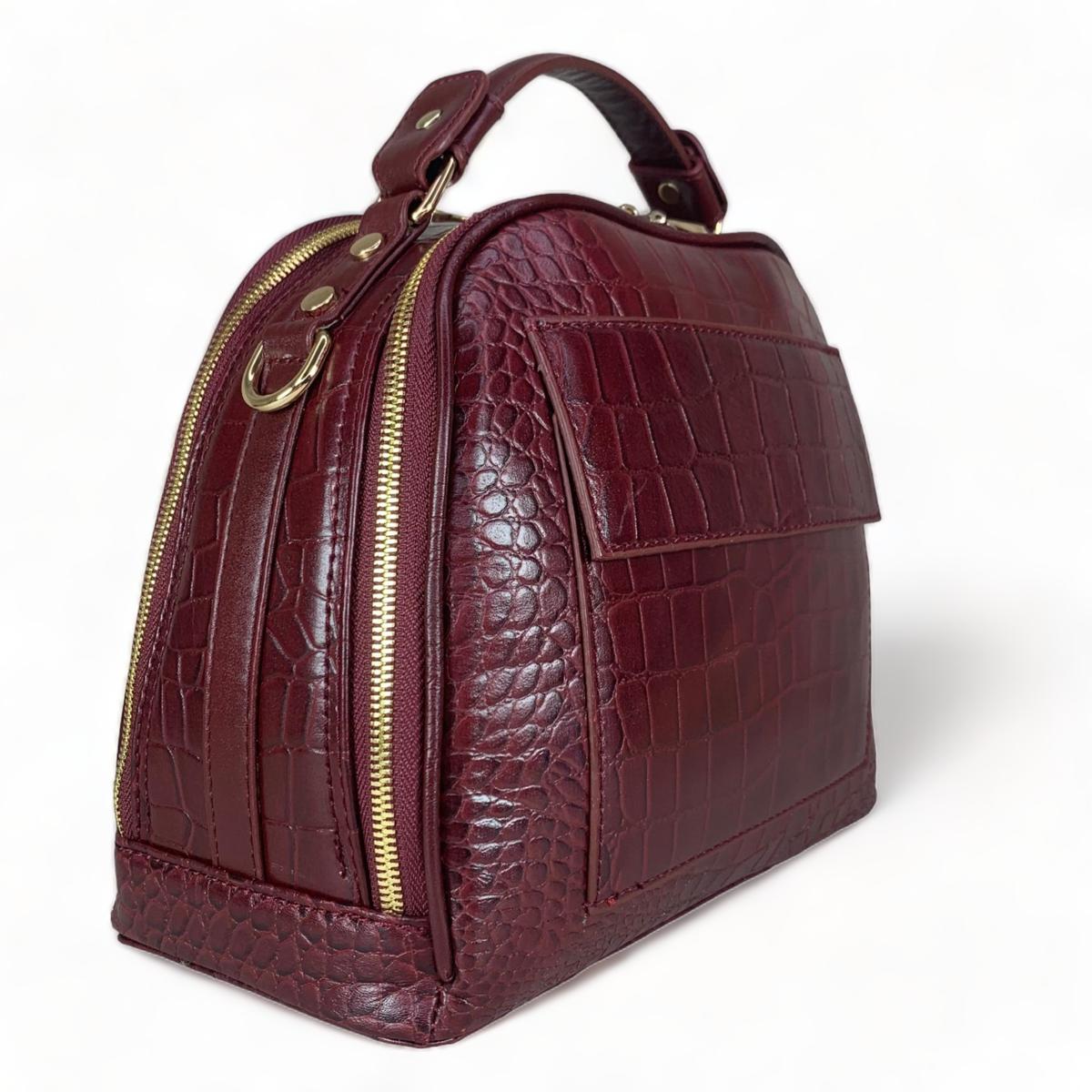Red leather handbag back view highlighting rear zip pocket and construction