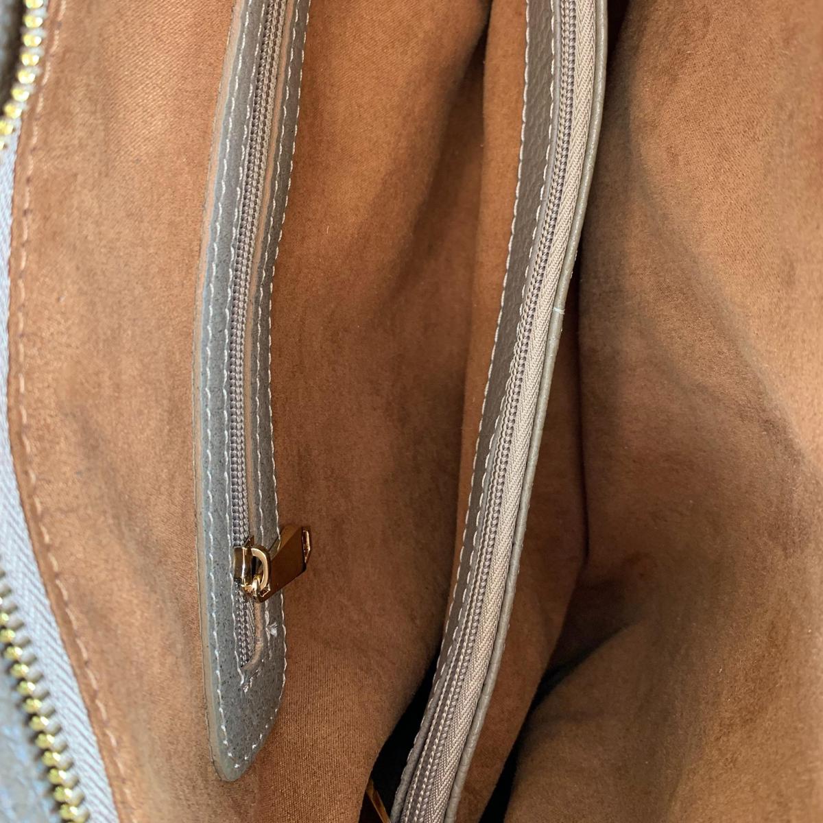 Interior view of khaki leather tote bag - showing multiple compartments and organizational features