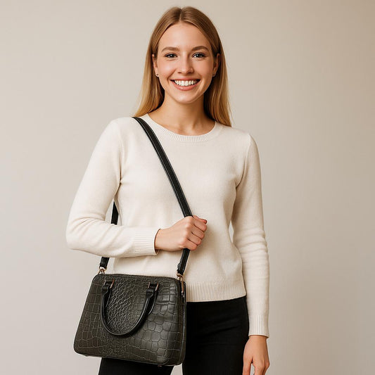 Woman holding a black handbag against a plain background