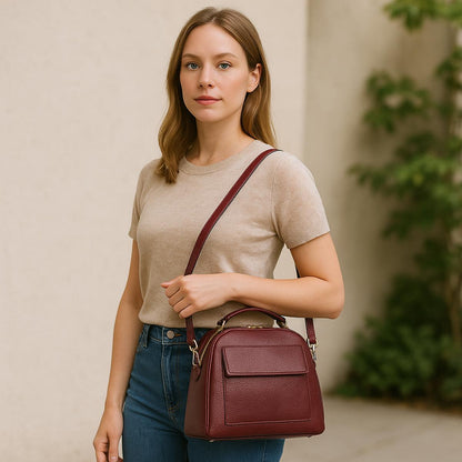 Woman wearing a dark red real leather satchel crossbody bag (medium) — lifestyle photo